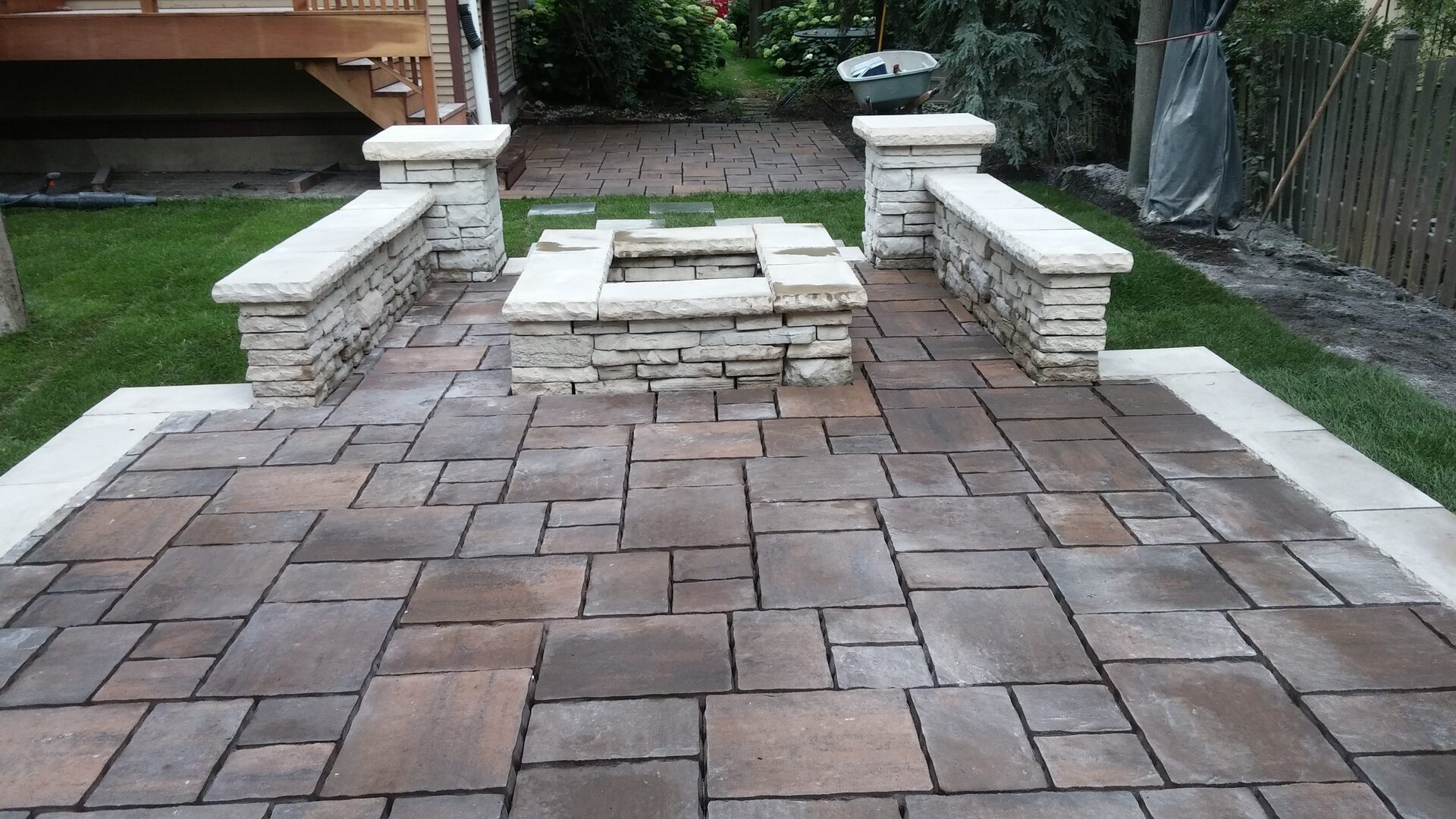 Custom stone patio with fire pit and seating walls