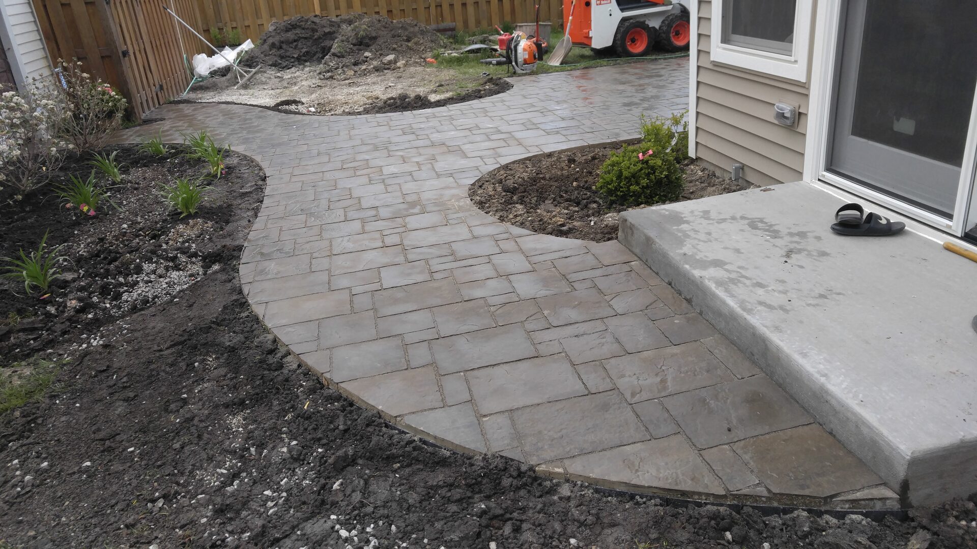 Curved stone paver patio installation